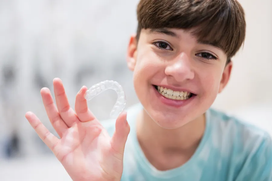 Child holding a clear aligner
